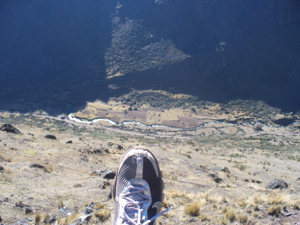 My foot hanging over a cliff The Lares trek features some very impressive trails that lead along very steep cliffs. Here I hang my foot over the edge to show the depth of the valley.